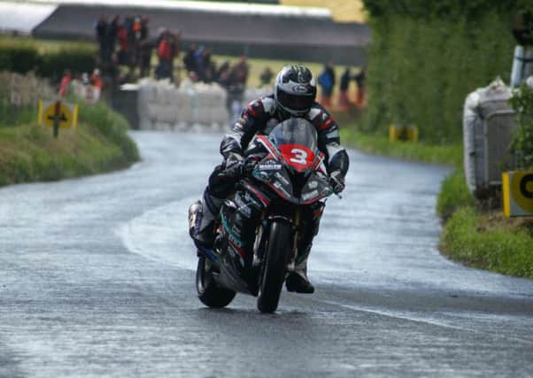 Michael Dunlop scrubs off speed in the rain. Pictures: Roy Adams.
