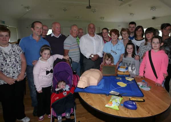 Josephine Higgins and members of her extended family with the defibrillator which they presented Glenravel Sports & Community Complex in memory of Joseph Higgins who died last year. Included is Ron Higgins who gave a demonstration to members of Ballymena Walking for Heath Group before the presentation.