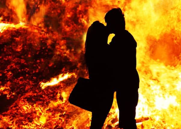Burning love - A couple embrace beside an 11th July bonfire at Ballymacash, Lisburn
