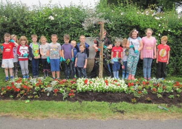 Children from St. Marys Primary School, Carrick Primary School, Seagoe Primary School and Derrytrasna Integrated Playgroup who planted a flowerbed in Charlestown Village