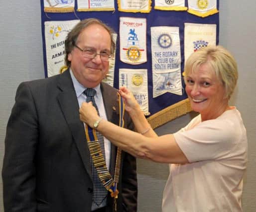 Brenda Houston, outgoing president of the Rotary Club of Carrickfergus, hands over the chain of office to Colin McCarthy, incoming president. INCT 29-703-CON.