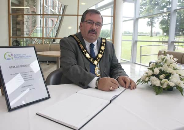Mayor John Scott signs the book of condolence at Mossley Mill. INNT 29-590CON