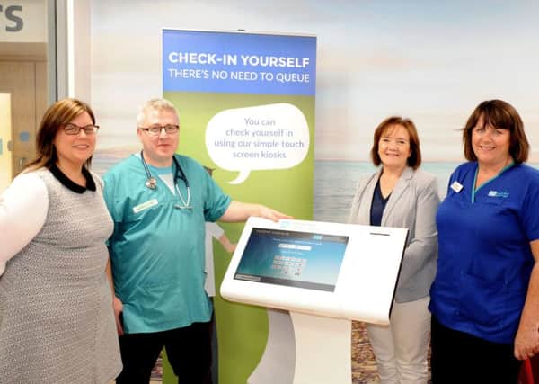 Michelle Kelly, Business Service Manager; Gavin O'Neill, Consultant in Emergency Medicine; Geraldine McKay, Director of Acute Services and Isobel McClintock, Emergency Department Manager stand with one of the two new self-check-in kiosks in Altnagelvin's Emergency Department.