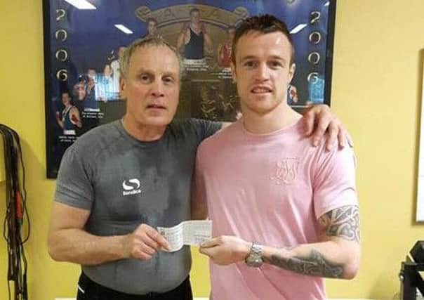 Tony McAvoy, of All Saints Boxing Club, presents a sponsorship cheque to Steven Donnelly to help with his preparations for the Olympic Games in Rio. The money was raised at a recent club function in the Adair Arms.
