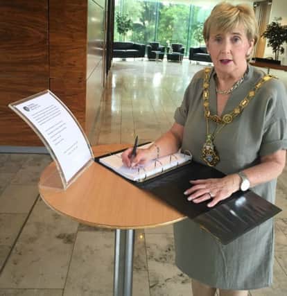 Mayor Hickey signs the Book of Condolences.