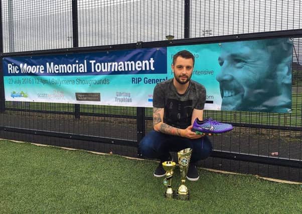 Ric Moore Memorial Cup organiser Jason Connolly pictured with the autographed pair of boots donated by Northern Ireland captain Steven Davis for this weekend's charity football tournament.