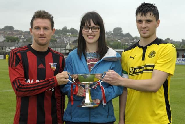 Banbridge Town Captain Ryan Moffatt and Cliftonville Captain Conor Doran pictured with Katie McKee, granddaughter of the late Bobby Larmour. Â©Paul Byrne Photography INBL1630-210PB