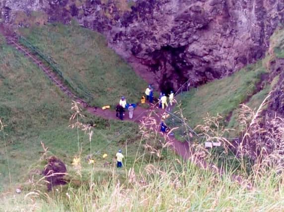 Coastguards recover the three uninjured tourists and their dog from the cave.