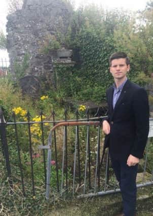 DUP Councillor Jonathan Buckley pictured beside the damaged Blacker family grave.