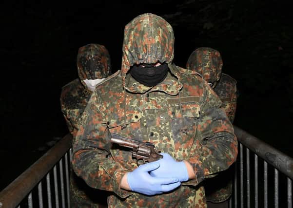 A masked and armed member of the republican dissident group Ã“glaigh na h-Eireann at a show of strength in the County Londonderry village of Park.