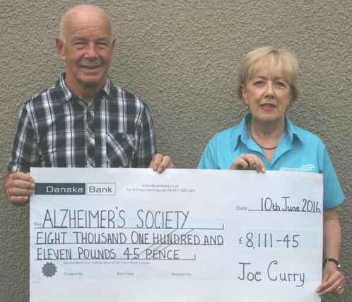 Joe Curry hands over the proceeds of his 60 mile run to Moira
 Shaw Volunteer Fundraiser Mid Ulster Area of the Alzheimers Society.