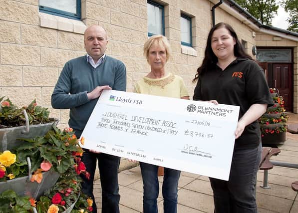 Victoria Graham and Dave from RES present a cheque to Jean McGarry representing the Loughgeil Development Association. 23465KDR