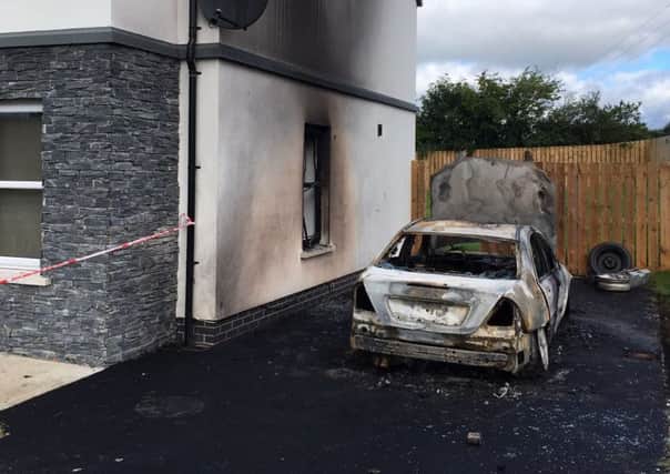 The brand new house which was damaged by fire in Ballinderry. The car, a Mercedes, was completely destroyed in the arson attack in the early hours of Wednesday morning.