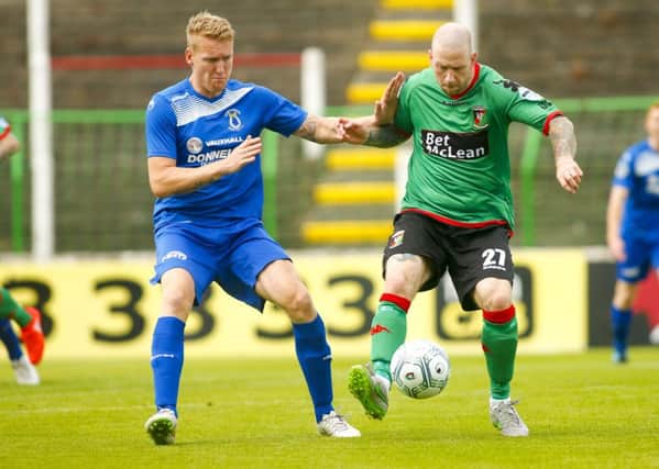 Glentoran striker Stephen O'Flynn takes on Dungannon defender Davy Armstrong
