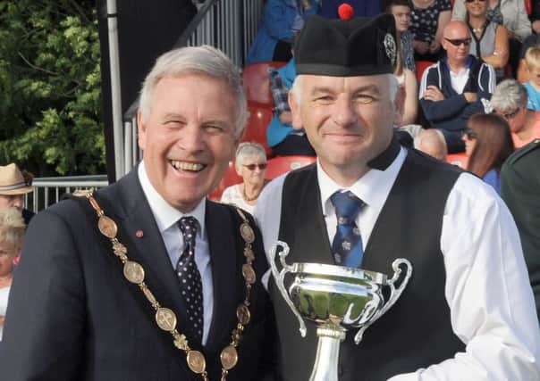Pipe Major John Fittis (right) from Ballyclare's Major Sinclair Memorial Pipe Band receives the trophy for third in Grade 3b and best M&D from the Chieftain of the Gathering, Councillor Brian Bloomfield MBE, Mayor of Lisburn & Castlereagh City Council, at the Lisburn & Castlereagh City Pipe Band Championships at Moira Demesne on Saturday, August 6. INNT 32-512CON Pic by John Kelly