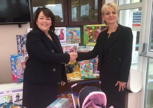 Tina McKenzie (left), Managing Director of PeoplePlus NI, is pictured handing over the donation of toys and games to the Director General of the Northern Ireland Prison Service, Sue McCallister.