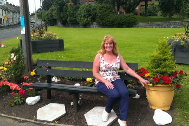 Ann Magee enjoys the view of the flowers she planted at the bottom of Mill Brae. INLT-33-702-con