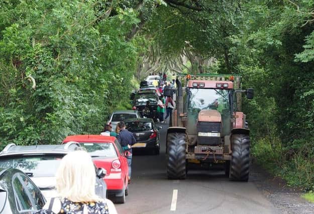 A farmer, with tractor and trailer, trying to earn a living, negotiates one of the biggest free car parks in the country - aka The 'Park' Hedges! Picture by Bob McCallion.
