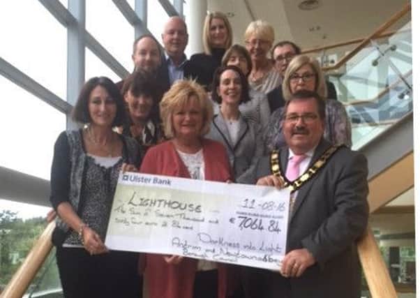Colette Snoddy (front left), Mayor John Scott and members of the Darkness Into Light organising committee present a cheque for 7,064 euro to Lighthouse co-ordinator Jo Murphy. INNT 33-599CON