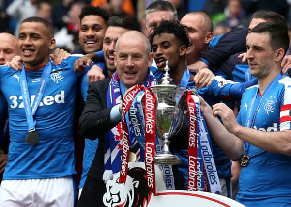 Rangers manager Mark Warburton  (centre) and Rangers' Lee Wallace with the Ladbrokes Scottish Championship trophy during the Ladbrokes Scottish Championship match at the Ibrox Stadium, Glasgow. PRESS ASSOCIATION Photo. Picture date: Saturday April 23, 2016. See PA story SOCCER Rangers. Photo credit should read: Andrew Milligan/PA Wire. EDITORIAL USE ONLY