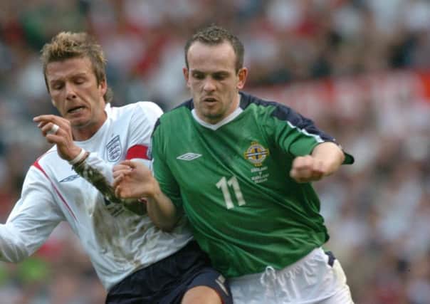 Ex-Irish League star Stuart Elliott battles for possession of the ball against England's David Beckham in 2005.