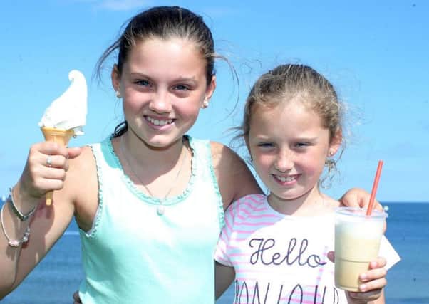 Blathnaid Donnelly(11) and her sister Dearbhla(9) from Tyrone enjoy some ice-cream ay the beach