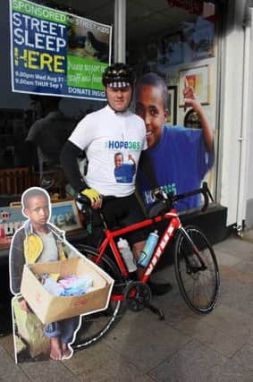 Stephen Hunter with a photo of Debiyso, one of the street children who will be moving in to the new home in Ethiopia which Stephen is raising money for by cycling 500 miles. INLT 36-703-CON