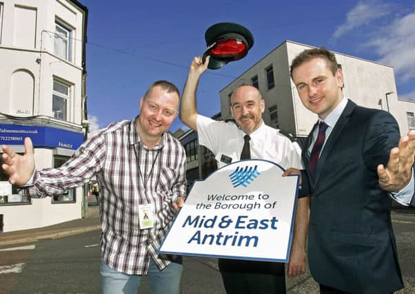 Detached Youth Worker, Daire Brownlee, (left) who works for the Bytes Project, is pictured 'signposting the way' to a warmer welcome across all of the Borough with the PSNIs Mid and East Antrim District Commander, Superintendent Ryan Henderson and Councillor Andrew Wilson, Chair of Mid and East Antrim Policing and Community Safety Partnership (PCSP).