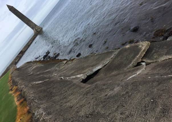 A loose slab and cracks in the side of the sea wall near Chaine Memorial Tower. INLT-37-716-con