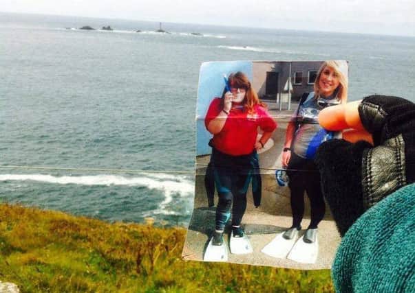 Lydia holds up a snapsnot of herself and Hannah on reaching Land's End.  INCT 37-730-CON