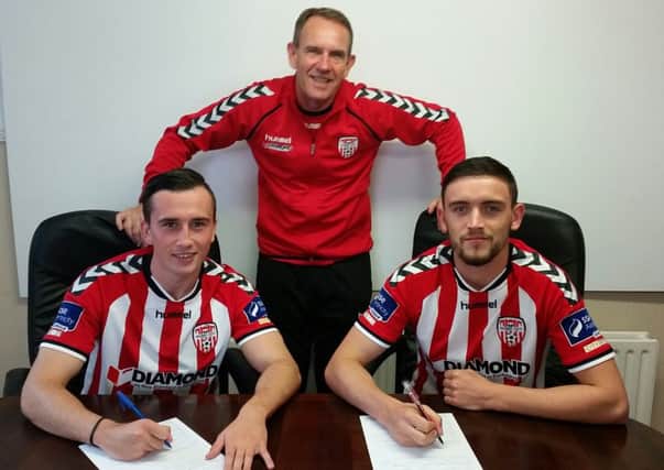 Derry City manager Kenny Shiels pictured with Aaron McEneff (left) and Dean Jarvis, as the pair sign their new contracts.