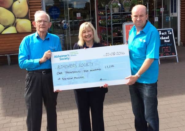 Bryan Clay (volunteer), Anne Broome (Tesco Community Champion) and Brian Patterson (volunteer) with the cheque for the Alzheimer's Society.