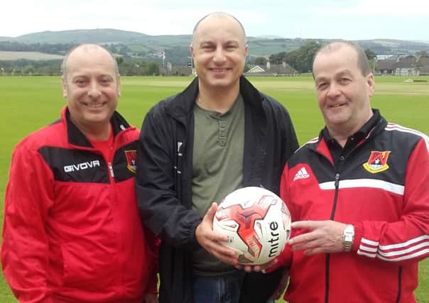 John Mamouzellos (Village Fryer) pictured presenting a sponsorship football to Ian Cooke (Foyle Wanderers Head of Youth left) and Trevor Kee (Foyle Wanderers Chairman).