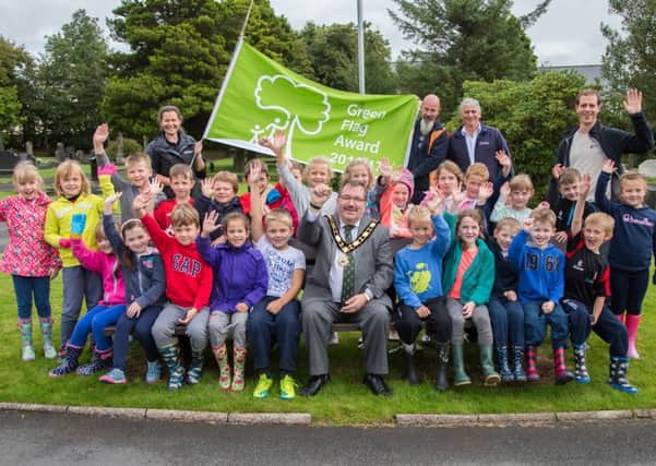 Mayor of Antrim and Newtownabbey, Councillor John Scott along with Council staff and pupils of Fairview Primary School at the official Green Flag raising ceremony at Ballyclare Cemetery.