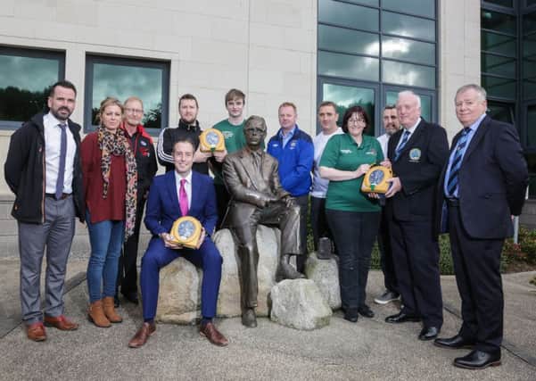 Minister Paul Givan MLA hands over defibrillators to Mark Montgomery and Scott Maine (Hazama Judo Club), Alison Slater and Philip Slater (Lisburn Gladiators Fencing Club), Michael Harrison and Colin McNeil (Rockmount Golf Club), Mark McCormick (Moira FC), Stephen Agnew and Aileen Agnew (Lisnagarvey Boxing Club), and Ken Stewart (Dundrod & District Motorcycle Club). Pic by Brian Thompson