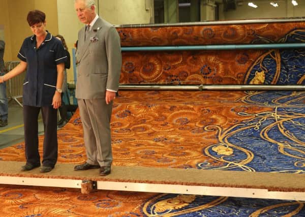 The Prince of Wales looks at a carpet during a visit to Ulster Carpets in May. Photo Brian Lawless/PA Wire