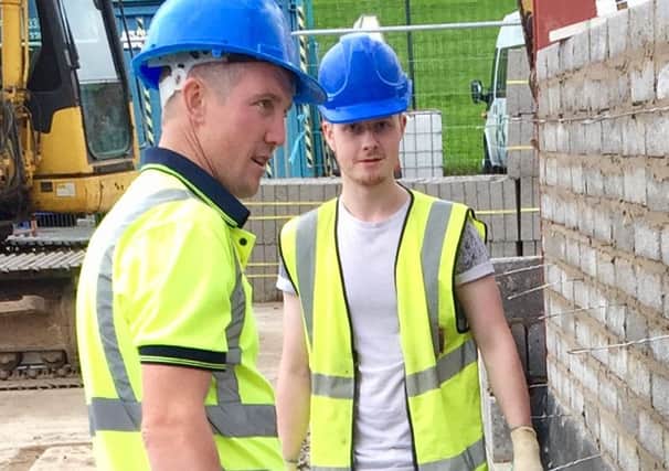 Jack McCutcheon (right) assisting the bricklayers from OB Construction on the extension to LaganView Enterprise Centre.
