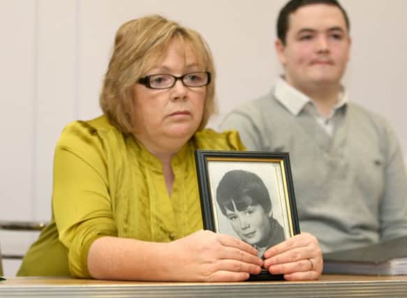 Helen Deery, the sister of Manus Deery with her son Sean, holding an image of Manus.