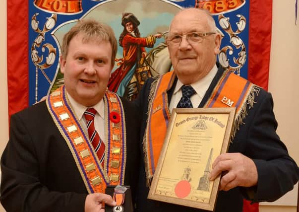 Bro. Robert Cantley of Tanvally LOL 383, receives a 50 Year Service Jewel and 60 Year Bar from Right Worshipful Bro. Harold Henninng, Deputy Grand  Master, Grand Orange Lodge of Ireland. Â© Photo: Gary Gardiner.  IN BL WK 4016-501.
