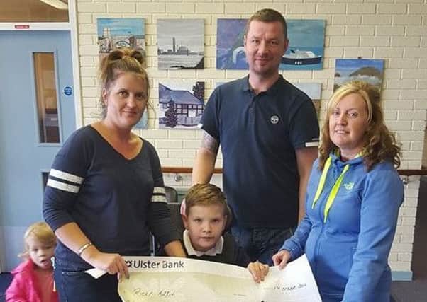 Larne boy Ricky Morrow and his family receive a cheque for Â£1075 from Christine Hyndman of Glenarm Community Focus. INLT-44-701-con
