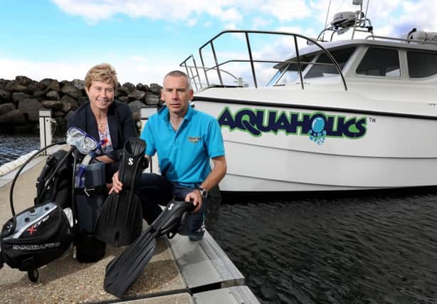 Richard Lafferty, owner of Portstewart-based Aquaholics with Rhonda McClelland of Ulster Bank at the new boat, moored in Ballycastle. INCR 44-793-CON
