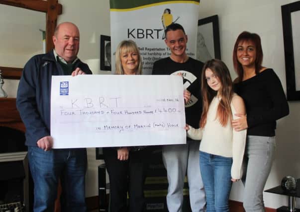 Colin Bell receives a cheque for Â£4,400 from Martin Hale's mother Teresa Temple, his brother Daniel Temple, sister Rebecca Temple and his daughter Cora McGreevy.