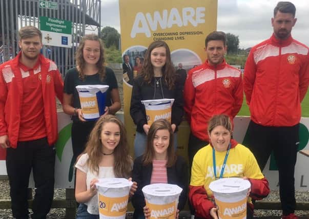Ruth McCauley, from right, collects at Portadown Fooball Club. Also pictured are  players Matty Parker, Matthew Rooney and Garry Breen, and some members of Edenderry Memorial Methodist Girls' Brigade. INPT45