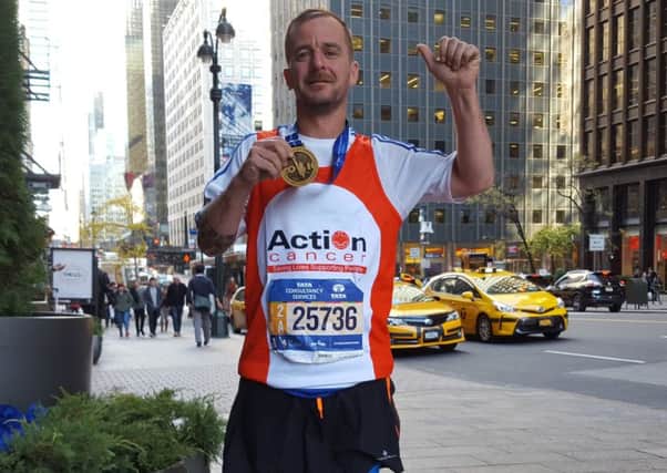 Peter Bell shows off his medal after completing the New York City Marathon in support of Action Cancer.