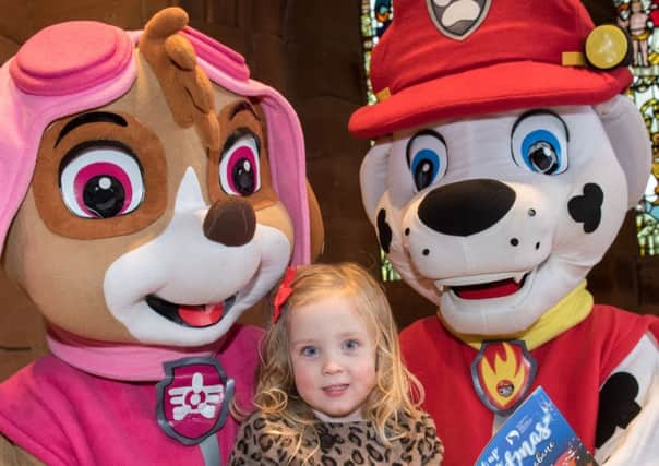 Three years old Maisie Flood reads Derry City and Strabane District Council's, "Light Up Your Christmas" guide  with Skye and Marshall from Paw Patrol. Picture Martin McKeown. Inpresspics.com.