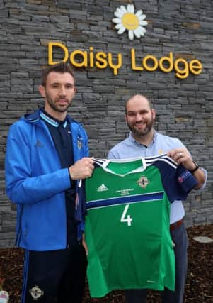 Gareth McAuley hands over his shirt he wore against Ukraine in the Euro's to Phil Alexander, Services Manager at Daisy Lodge, Cancer Fund for Children for an online raffle. Funds raised with support local children affected by cancer. Photo by William Cherry