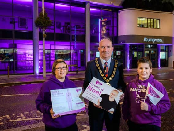 The Chair of Mid Ulster District Council, Councillor Trevor Wilson is pictured at the Burnavon, Cookstown, one of the Council buildings to be illuminated purple this month to raise awareness of pancreatic cancer, with Kerry Irvine, Action4Noel and her son Nathan