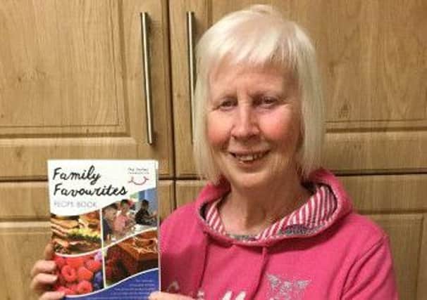 Joye Carson with the cook book she has compiled in support of the Smiles Foundation, (Romania).