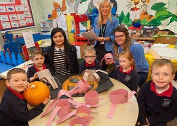Level 3 BTEC Extended Diploma in Travel & Tourism students, Errize Zapatc and Celine McNeill and lecturer Karen McLeod from Northern Regional College pictured with pupils from Harryville Primary School,