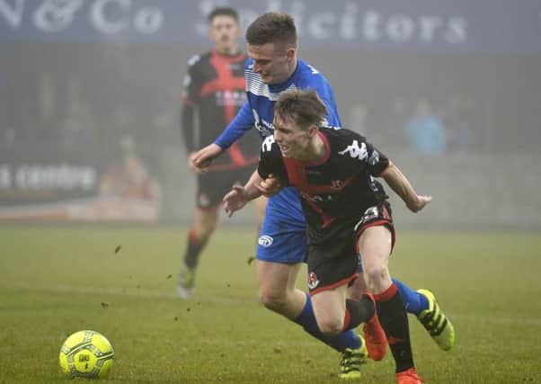 Dungannon's Dougie Wilson in action with Crusaders' Gavin Whyte.